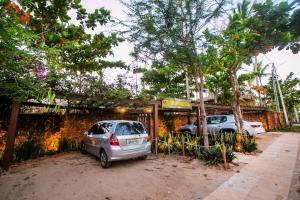 dos coches estacionados frente a un edificio en Bangalô Kauli Seadi Eco-Resort, en São Miguel do Gostoso