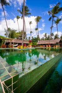una piscina in un resort con palme di Bangalô Kauli Seadi Eco-Resort a São Miguel do Gostoso