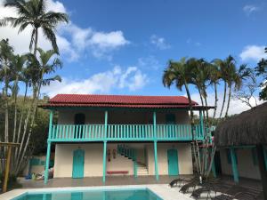 una casa con piscina y palmeras en Pousada Maria Felipa Ilhabela en Ilhabela