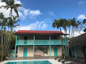 una casa con piscina e palme di Pousada Maria Felipa Ilhabela a Ilhabela