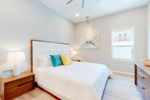 Un dormitorio blanco con una cama grande y una ventana. en Dolphin Paradise Unit B, en South Padre Island 19 fotos más