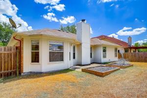 a yellow house with a fence in a yard at Brickhouse Retreat in Round Rock