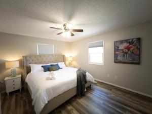 1 dormitorio con 1 cama y ventilador de techo en Subtle comfort and style in quiet neighborhood., en Joplin