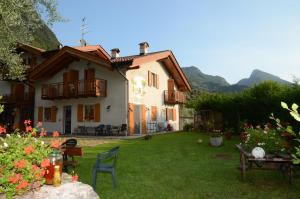 a house with a yard with chairs and tables at Agritur Girardelli in Riva del Garda