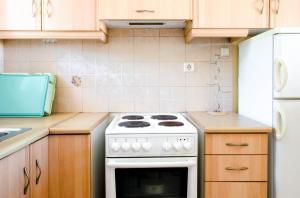a kitchen with a white stove and a refrigerator at STUDIOS ATHENA in Megalochori