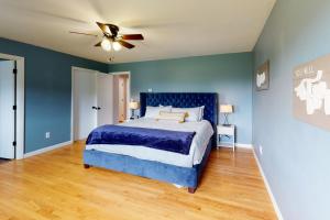 - une chambre bleue avec un lit et un ventilateur de plafond dans l'établissement Camel's Hump Hideaway, à South Burlington