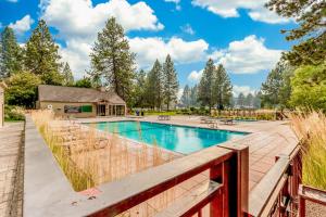 a swimming pool with chairs and a wooden fence at Alpine Escape in Bend