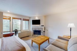 Alpine Escape في بيند: غرفة معيشة مع أريكة ومدفأة