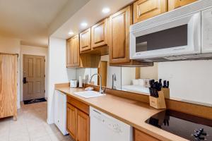 a kitchen with wooden cabinets and a microwave at Alpine Escape in Bend
