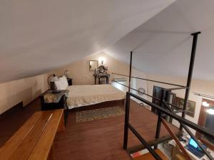 a attic room with a bed and a staircase at Villas El Paradiso in Kouroúpi