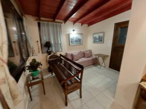 a living room with a couch and a piano at Villas El Paradiso in Kouroúpi