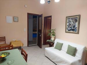 a living room with a white couch and a table at Villas El Paradiso in Kouroúpi
