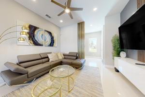 a living room with a couch and a tv at Dolphin Paradise Unit A in South Padre Island