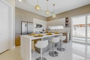 a kitchen with a large white island with bar stools at Dolphin Paradise Unit A in South Padre Island