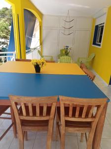 a dining room with a blue and yellow table and chairs at Maison mitoyenne in Garnier