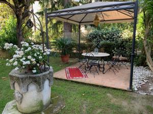 a table and chairs under an umbrella in a garden at Golden Ravenna- large appartment in center in Ravenna