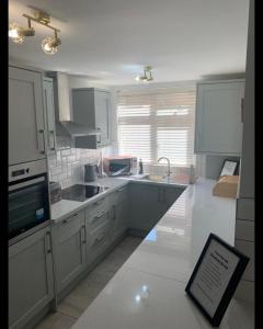 a kitchen with white cabinets and a sign on the floor at Beautiful Room in Apartment near Town Centre in Rugby