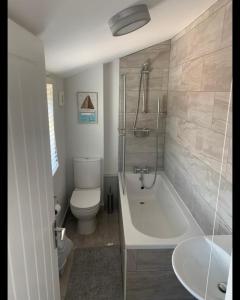 a bathroom with a tub and a toilet and a sink at Beautiful Room in Apartment near Town Centre in Rugby