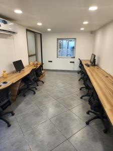 an office with long desks and chairs and a window at Coliwo Un - VIman Nagar in Pune