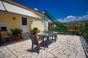 un patio con tavolo, sedie e scala di VILA SHAMETAJ a Gjirokastër
