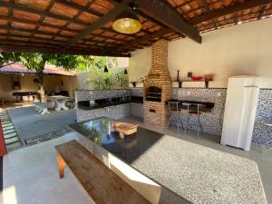 uma cozinha exterior com uma lareira e uma mesa em Chácara Paraíso do Rio em Aracaju em Aracaju