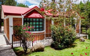 een klein huis met een hek in een tuin bij Villas Xänthe Rotamundos in Huasca de Ocampo