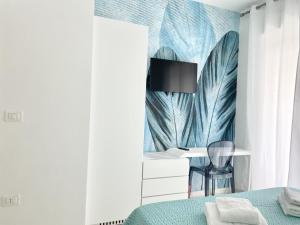 a bedroom with a bed with a wall mural of feathers at IL VIAGGIATORE RELAIS SUL MARE in Gaeta