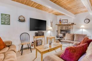 sala de estar con sofás, TV y chimenea en Edelweiss Retreat, en Government Camp