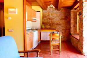 a kitchen with a table and chairs in a room at Apartamentos Rurales Las Cuendias in Perlunes