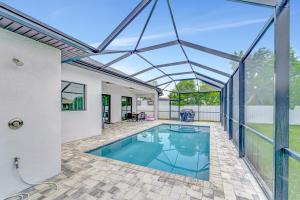 a swimming pool in a house with a glass roof at Seashell of the Ball in Cape Coral