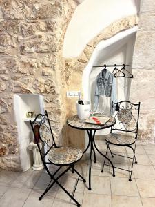 einen Tisch und Stühle in einem Zimmer mit einer Steinmauer in der Unterkunft Tama67 suite in Ostuni