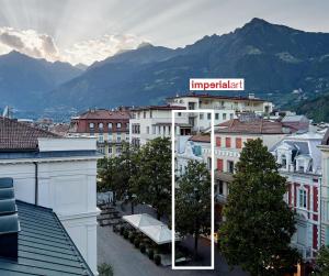 duas fotos de uma cidade com uma placa no topo dos edifícios em Boutique Hotel Imperialart em Merano