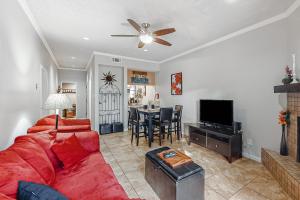 a living room with a red couch and a tv at Camp Warnecke Estates Unit B104 in New Braunfels