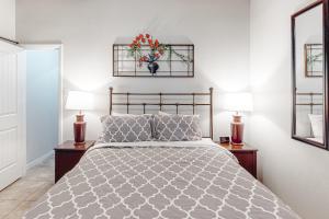 a bedroom with a bed and two lamps and a mirror at Camp Warnecke Estates Unit B104 in New Braunfels