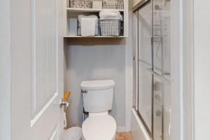 a white bathroom with a toilet and a shower at Camp Warnecke Estates Unit B104 in New Braunfels