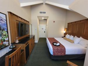 um quarto de hotel com uma cama e uma televisão de ecrã plano em Kilmorey Lodge em Waterton Park