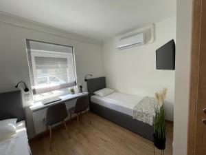 札雷格塞格的住宿－D 20 Apartmanház Zalaegerszeg Dózsa György utca 20，小房间设有床、书桌和窗户