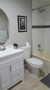 a bathroom with a toilet and a sink and a mirror at T-Designed to ENJOY!. Best Vacation in Las Vegas