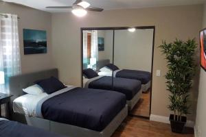 a bedroom with three beds and a mirror at T-Designed to ENJOY!. Best Vacation in Las Vegas