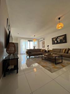 a living room with two couches and a table at Brand new apartment 2 mins from Seafront in St Paul's Bay