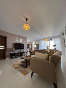 a living room with a couch and a tv at Brand new apartment 2 mins from Seafront in St Paul's Bay
