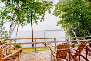 une terrasse avec des chaises et une table et une vue sur l'eau dans l'établissement Lakefront Cottage #1, à Greenville