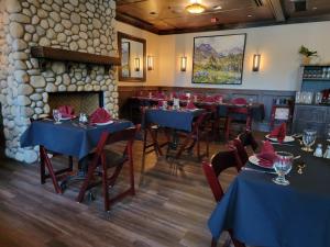 a dining room with tables and chairs and a fireplace at Kilmorey Lodge in Waterton Park