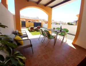 a living room with a table and chairs on a patio at Bungalow Flor de Lirio in Mazarrón