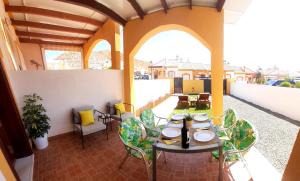 a patio with tables and chairs on a balcony at Bungalow Flor de Lirio in Mazarrón