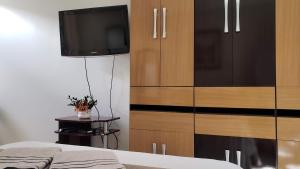 a bedroom with a dresser and a tv and a bed at Descanse na rede da varanda em um local nota 10 e Wi Fi top! in Brasilia