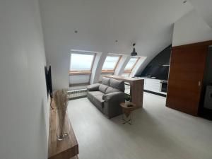 a living room with a couch and some windows at BALCÓN DO MARIÑEIRO in Burela de Cabo