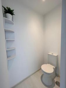 a white bathroom with a toilet and a shelf at BALCÓN DO MARIÑEIRO in Burela de Cabo