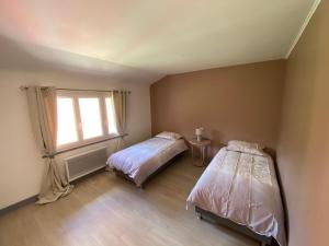 a bedroom with two beds and a window at La ferme Sainte-Damaris de la Maurienne 