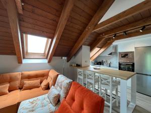 uma sala de estar com um sofá laranja e uma cozinha em BPIRINEOS-Aigualluts em Benasque